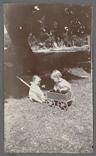 Klaas en Tiny Kleiterp spelend met een kar op een grasveld in Nederlands-Indië
