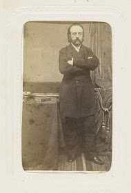 Portret van een staande man naast een tafel