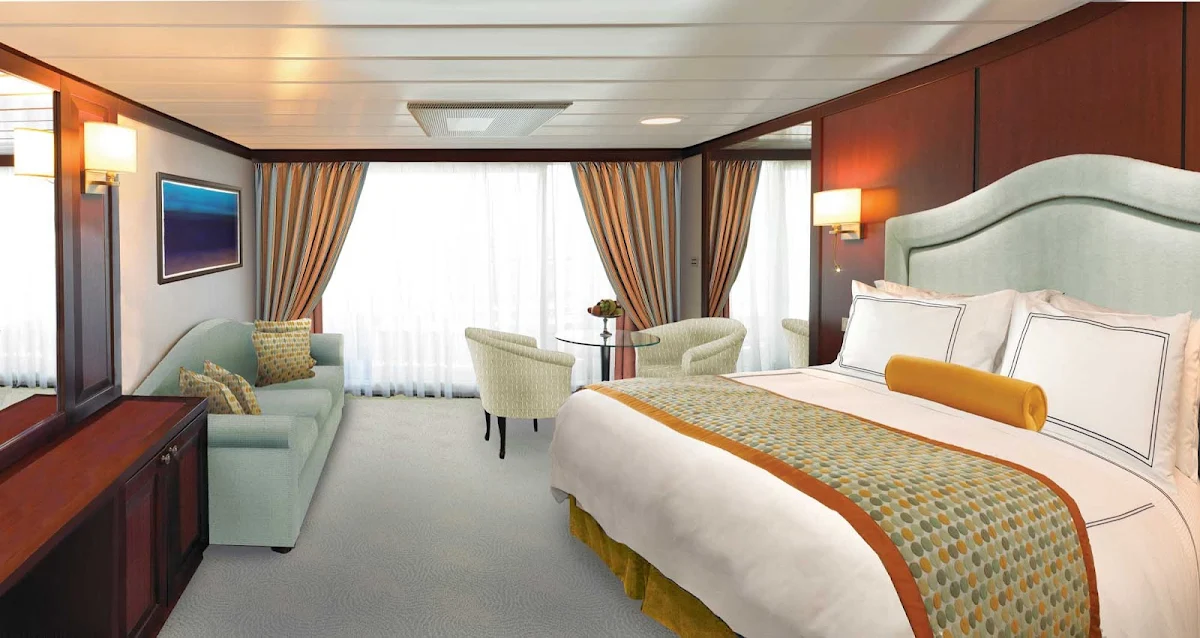 Oceania-Penthouse-Suite-R-1 - Choose Oceania Regatta's Penthouse Suite for 322 square feet of comfort: a queen-size Tranquility Bed that can be converted into two twins, a private teak veranda to enjoy the views, vanity desk, bath with tub, seating area, refrigerated mini-bar, customized entertainment system and butler service. 