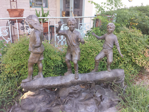 Three Children On A log Statue