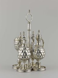 Specerijenservies, bestaande uit een blad met afschroefbare houder, oliekan, twee strooiers, waarvan één met ronde, de ander met ruitvormige gaten in het deksel, en een zoutvat.
