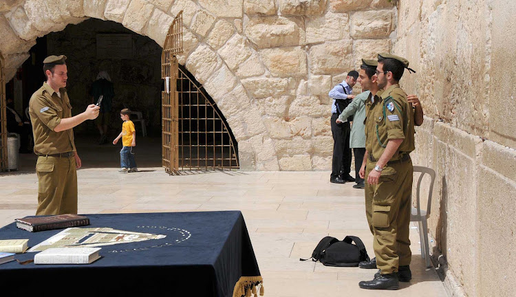Israeli soldiers pose for photos at the Western Wall in Old Jerusalem. 