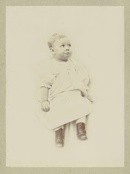 Portret van een jong kind in een jurk met rijglaarzen