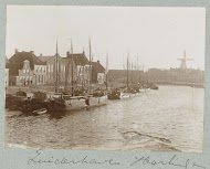 Havengezicht met platbodems en molen