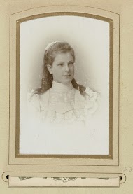 Portret van een meisje in een witte jurk met een strik in het haar