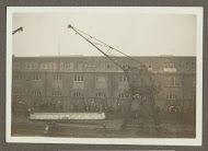 Wuivende mensen, een hijskraan en een valreep op een kade