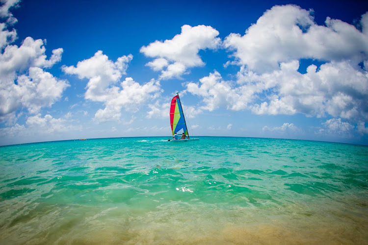 A Hobie Cat catamaran sailboat plies the pristine waters of Anguilla in the Caribbean. 