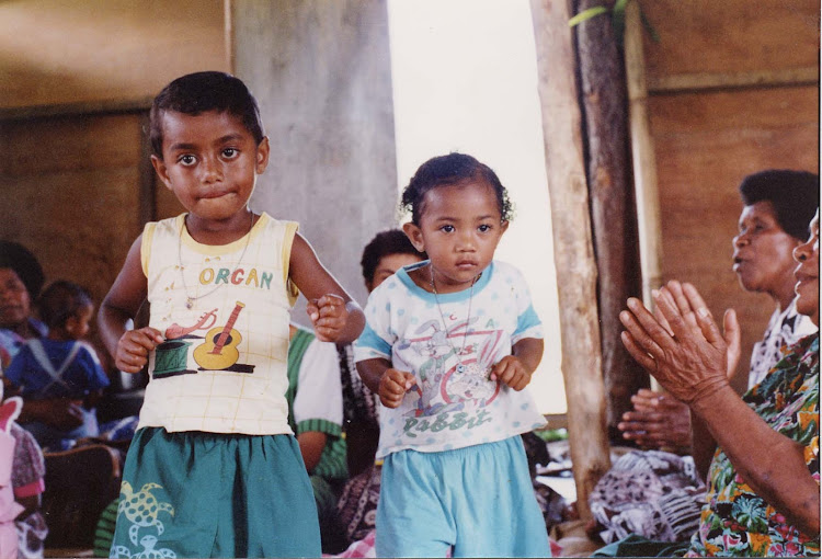 Solo, 4, and Mariana, 3, dance to Fijian music during a meke in the small village of Namuamua in the interior of Fiji's main island.