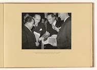 De heren Mr Moh. Roem en Dr J.H. van Royen bekijken de foto's, genomen tijdens de radiouitzending, waarin zij het "slotaccoord" bespraken