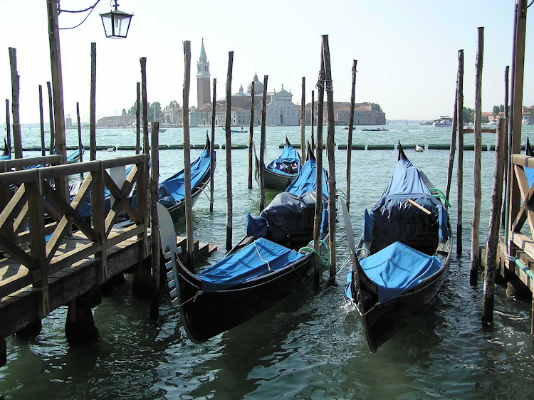 Idle gondolas near Piazza San Marco in Venice, Italy. All Venice gondolas are painted black in memory of 50,000 Venetians who lost their lives during the black plague. 