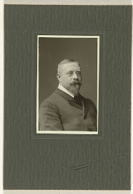 Studioportret van een man met snor, baard en bril