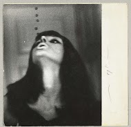 Portret van een vrouw met donker, loshangend haar, zwart omrande ogen en lichte lippen