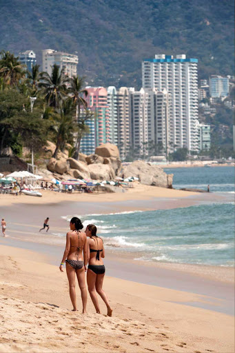 Acapulco-beach - Two women walk on Acapulco's world-famous beach.