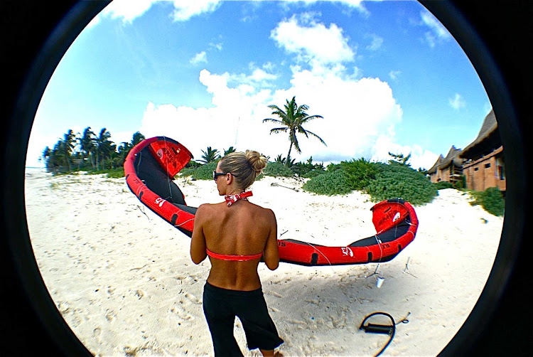 A kiteboarder waits for her turn on the beach in Mexico. 