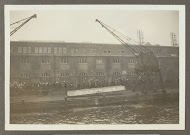 Wuivende mensen, een hijskraan en een valreep op een kade