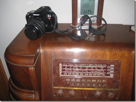 camera sitting on old tube radio
