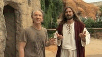 Image shows scene from Religilous featuring Bill Maher standing beside a man dressed like Jesus