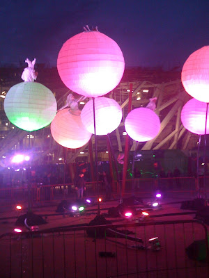 photo shows a number of giant, inflatable spheres in different luminous colours with people on them