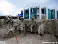 Statues of children enjoying music. Behind them is the New City Hall in Tagum City.