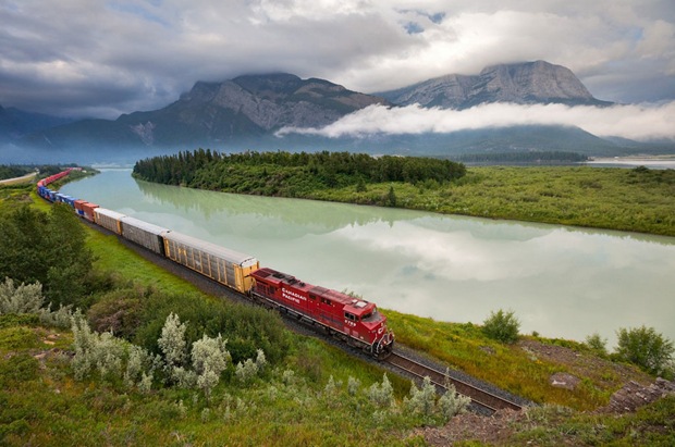 Canadian Pacific Railway train passes an amazing green landscape at Exshaw, Alberta, Canada 