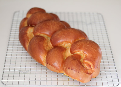 photo of a loaf of challah bread on a baking rack