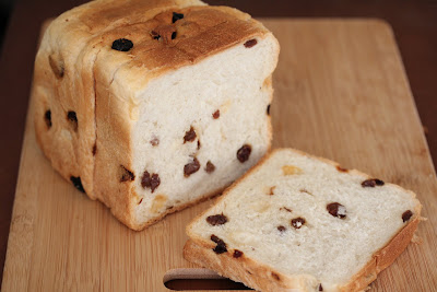 photo of a loaf of raisin bread with a slice cut off