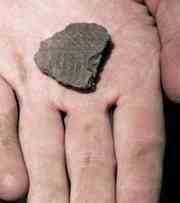 Andrew Boyles holds a piece of decorated ceramic pottery he found in a unit he was digging in at the Finch Site