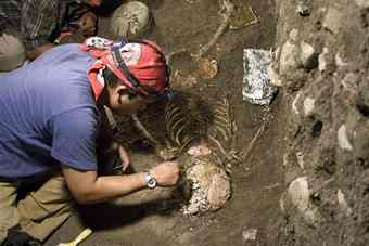 Archaeologist Emiliano Gallaga works on the skeletal remains of a woman found inside a tomb in the ancient city of Chiapa de Corzo, Chiapas, Mexico