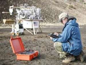 Decades of work preparing a miniaturized laboratory for identifying minerals on Mars have also yielded spinoff versions with diverse applications on Earth and, possibly, the moon. This image shows one of the spinoffs, in the orange case, in use during a November 2008 expedition to the Mauna Kea volcano in Hawaii