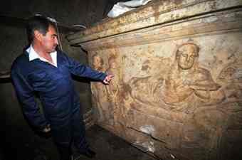 Turkish Culture Minister Ertugrul Gunay inspecting an ancient marble coffin inside an underground tomb in Milas, western Turkey.
