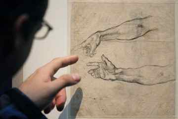 A visitor points at studies of arms for "The drunkenness of Noah" from Michelangelo Buonarroti made with black chalk 1509 at the Albertina museum, in Vienna, Austria, on Wednesday, Oct. 6, 2010. The exhibition called "Michelangelo drawing of a genius" is the first major show in more than 20 years and includes 120 of his most precious drawings. AP Photo/Ronald Zak