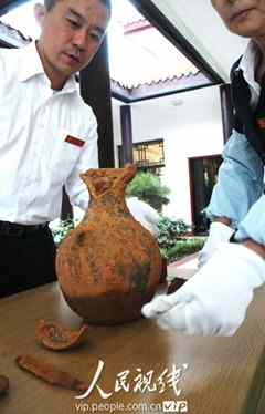 A pottery jar is unearthed from the ancient tomb. (photo by Xu Jixiang, People's Daily Online) 