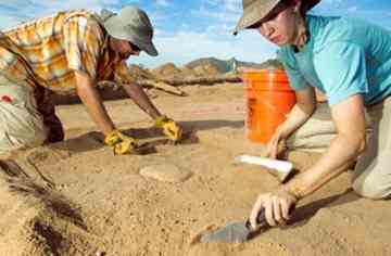 Field director Scott Courtright (left) and archaeologist Leigh Davidson dig up artifacts.
