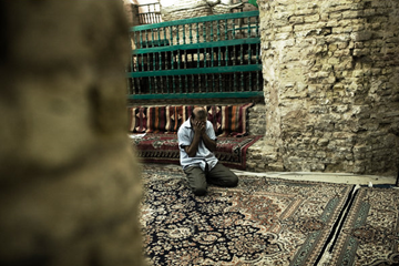 A Muslim man praying at the tomb of the Ezekiel.