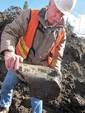 Dr. Steve Holen, curator of archaeology at the Denver Museum of Nature & Science, holds one of the large bones unearthed at the reservoir. “Being an archeologist, in my mind, the big question is, were humans here? We don't know yet,” he said. [Courtesy Denver Museum of Nature & Science]