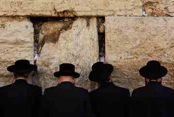 Jewish men pray at the Western Wall, the holiest site where Jews can pray, in Jerusalem's Old City. AP Photo/Kevin Frayer. 