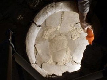 A flashlight illuminates the inside of the vat into which the wine press drained. On the inner surface of the vat below its rim, UCLA chemists found evidence of the plant pigment malvidin, the substance that makes wine stains so difficult to remove from fabric today. [Photo: Reuters]
