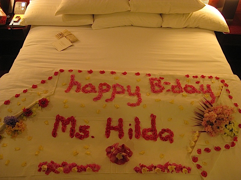 a floral birthday greeting on our bed at Bellarocca Island Resort