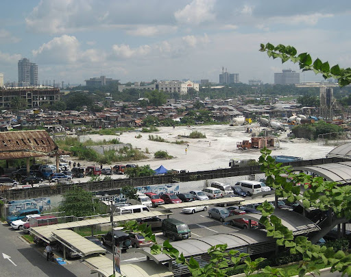 large urban poor community beside an upscale mall