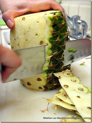 Cutting the skin off the pineapple