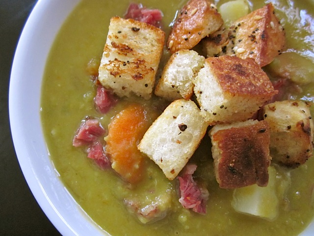 Close up of a bowl of Chunky Split Pea Soup with croutons on top