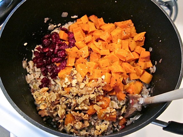 sweet potatoes and and cranberries added to wild rice mix in pot 