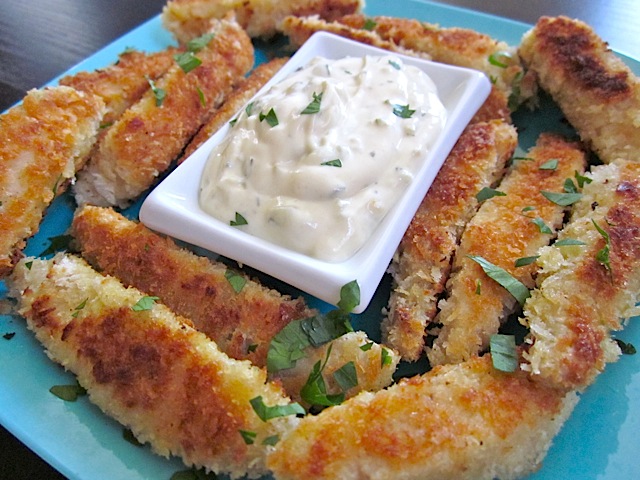 Tartar like sauce placed on blue plate with fish sticks to dip 