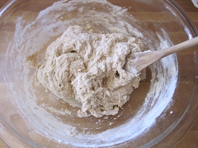 wet and dry ingredients combined in mixing bowl with wooden spoon
