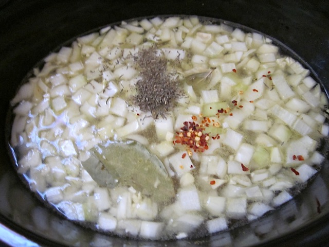 chicken broth and seasoning added to black eyed pea mixture in slow cooker 