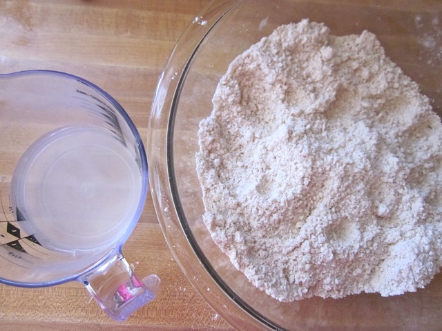 salt and water being added to flour in mixing bowl