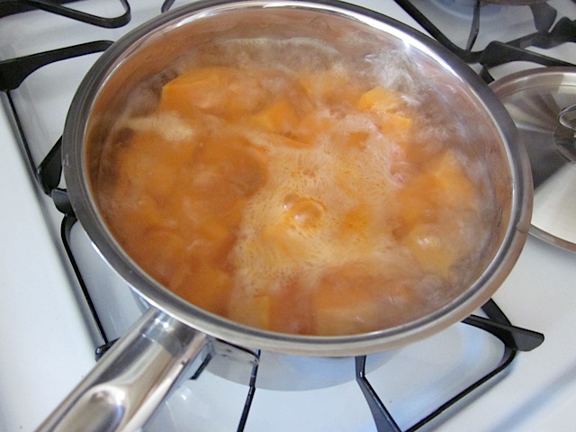 Boiling sweet potatoes in pot on stove top 