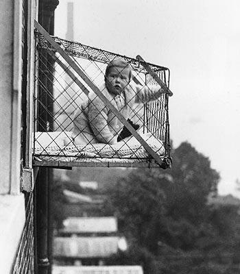 Bebés colgados con jaulas del balcón para que se refresquen