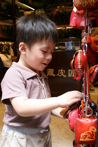 挑皮包，在台灣常見的東西對祐祐來說倒也稀奇，讓他看足了十二生肖造型包再走也不遲。