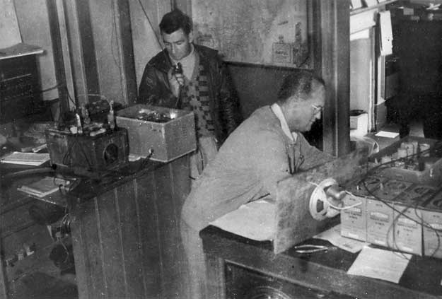 [Aeradio men Charles Pedell (left) and J Pickles operate emergency equipment. Kempsey floods 1949[4].jpg]